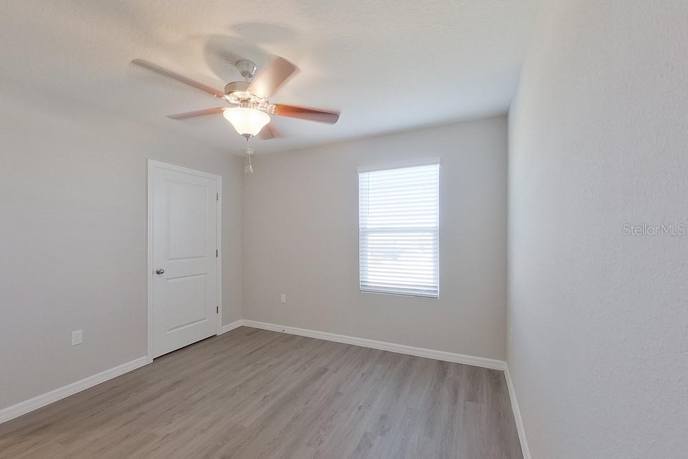 4397 Southwest 85th Lane Ocala, FL 34476 - Photo 11 of 23 an empty room with wooden floor fan and windows