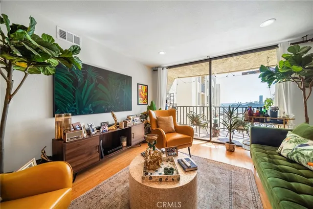 a living room with furniture potted plant and a large window