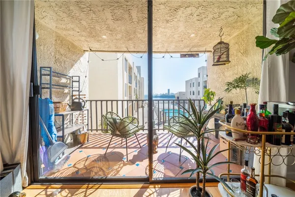 a view of a balcony with furniture and floor to ceiling window