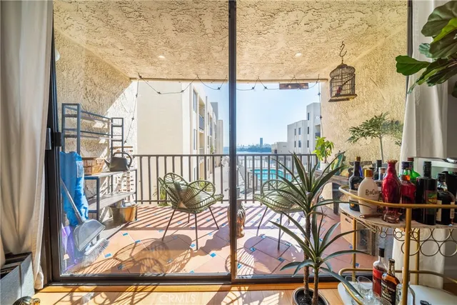 a view of a balcony with furniture and floor to ceiling window