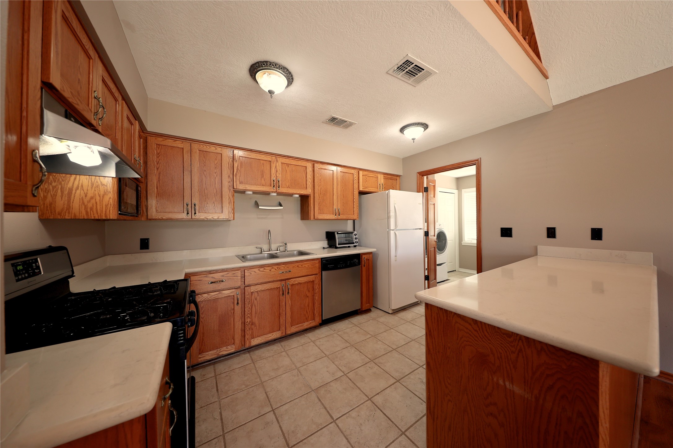 3337 Brunes Mill Road Columbus, TX 78934 - Photo 7 of 48 a large kitchen with kitchen island a sink white cabinets and appliances