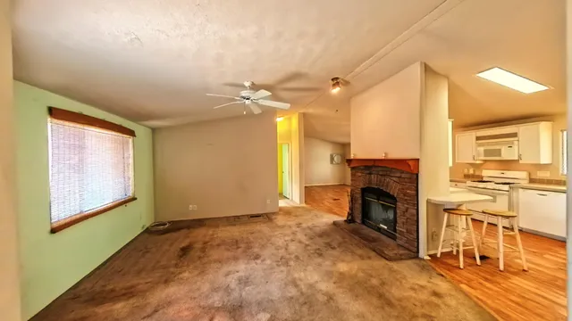 a view of empty room with window and wooden floor