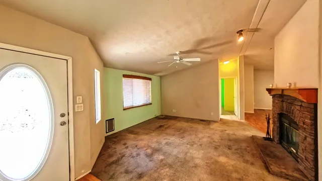 en empty room with window and a kitchen