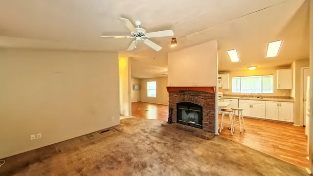 a view of a big room with wooden floor and windows