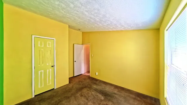 a view of a hallway with wooden floor and a bathroom