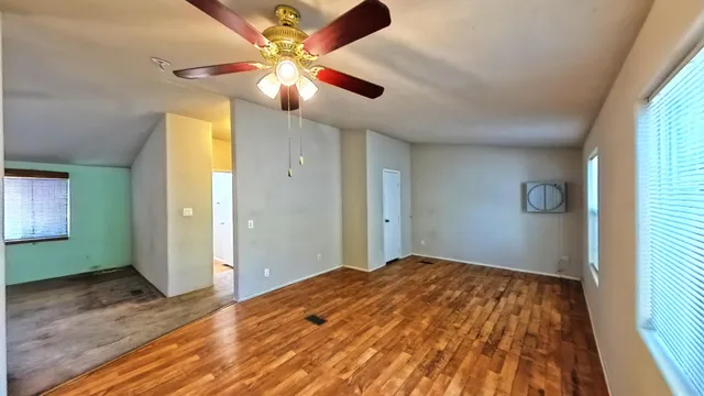 a view of a kitchen with kitchen island granite countertop wooden floor and stainless steel appliances