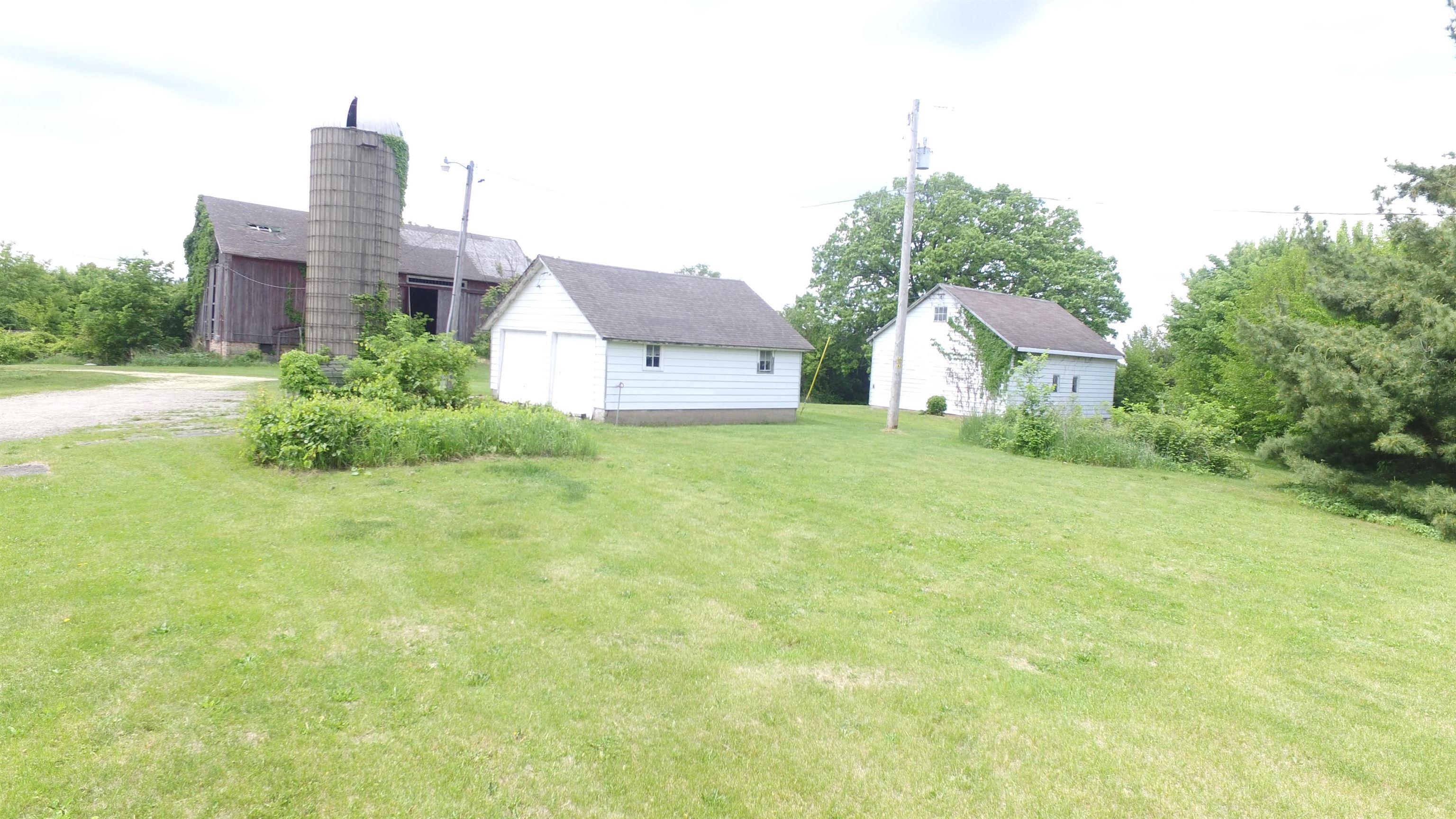 5250 Harvey Road Caledonia, IL 61011 - Photo 10 of 17 a front view of a house with a yard and garage
