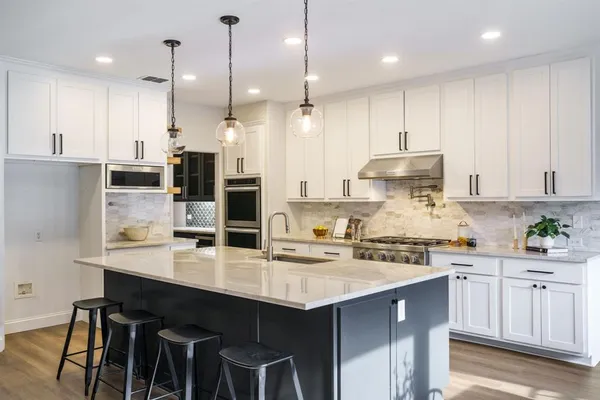 a kitchen with kitchen island granite countertop a sink a center island and cabinets