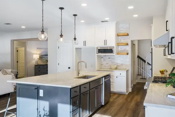a kitchen with stainless steel appliances kitchen island granite countertop a sink refrigerator and cabinets