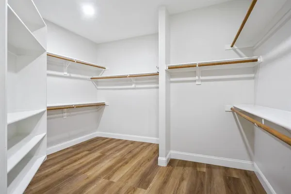 a view of walk in closet with empty racks