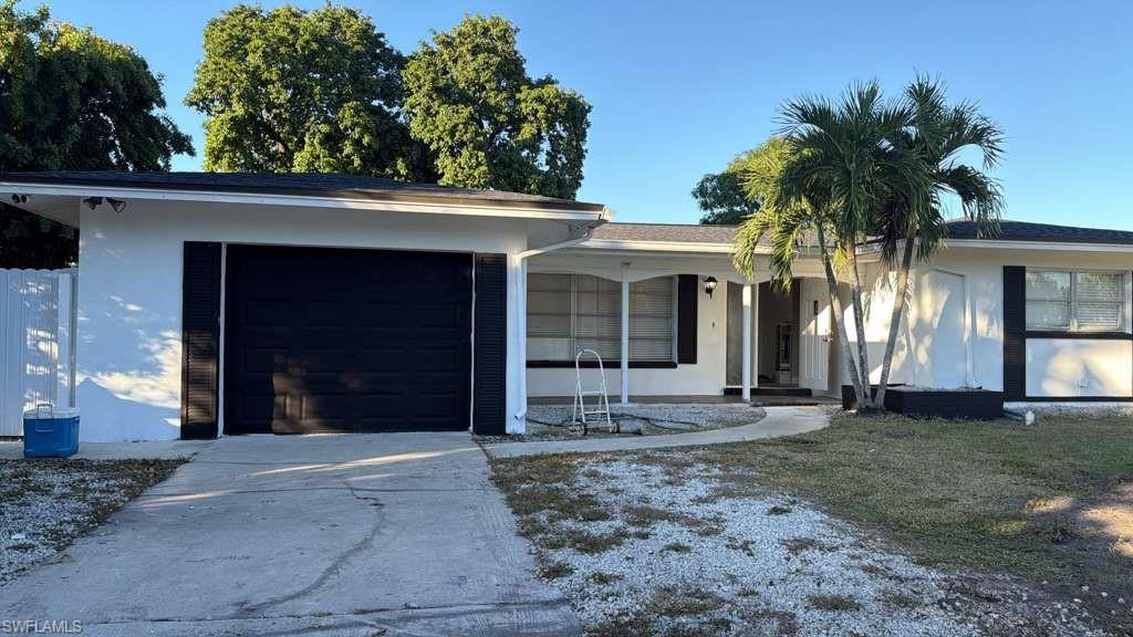 4439 23rd Place Southwest Naples, FL 34116 - Photo 1 of 15 Ranch-style home featuring driveway, an attached garage, and stucco siding