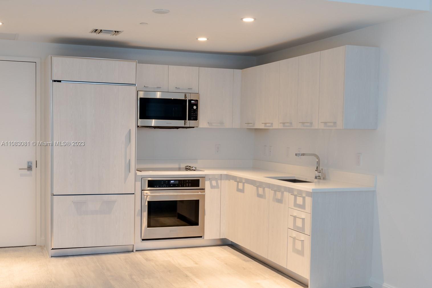 45 Southwest 9th Street, Unit 2207 Miami, FL 33130 - Photo 8 of 31 a kitchen with a stove and a microwave