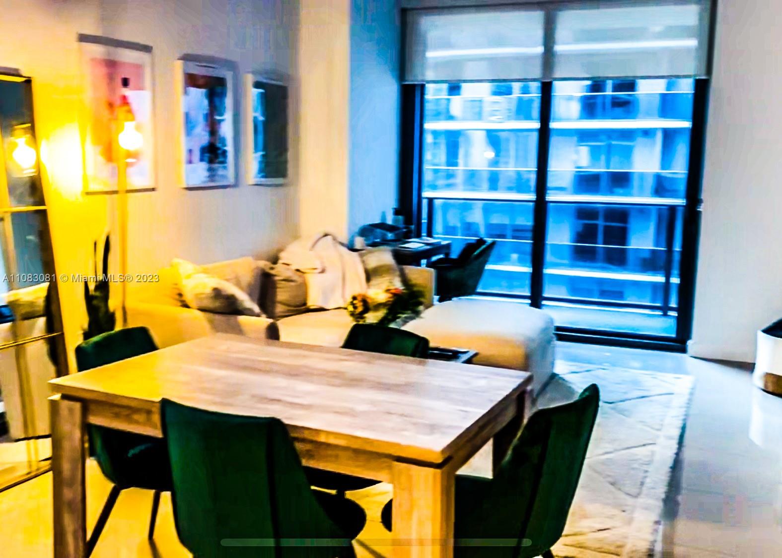 45 Southwest 9th Street, Unit 2207 Miami, FL 33130 - Photo 9 of 31 a view of a dining room with a table and chairs