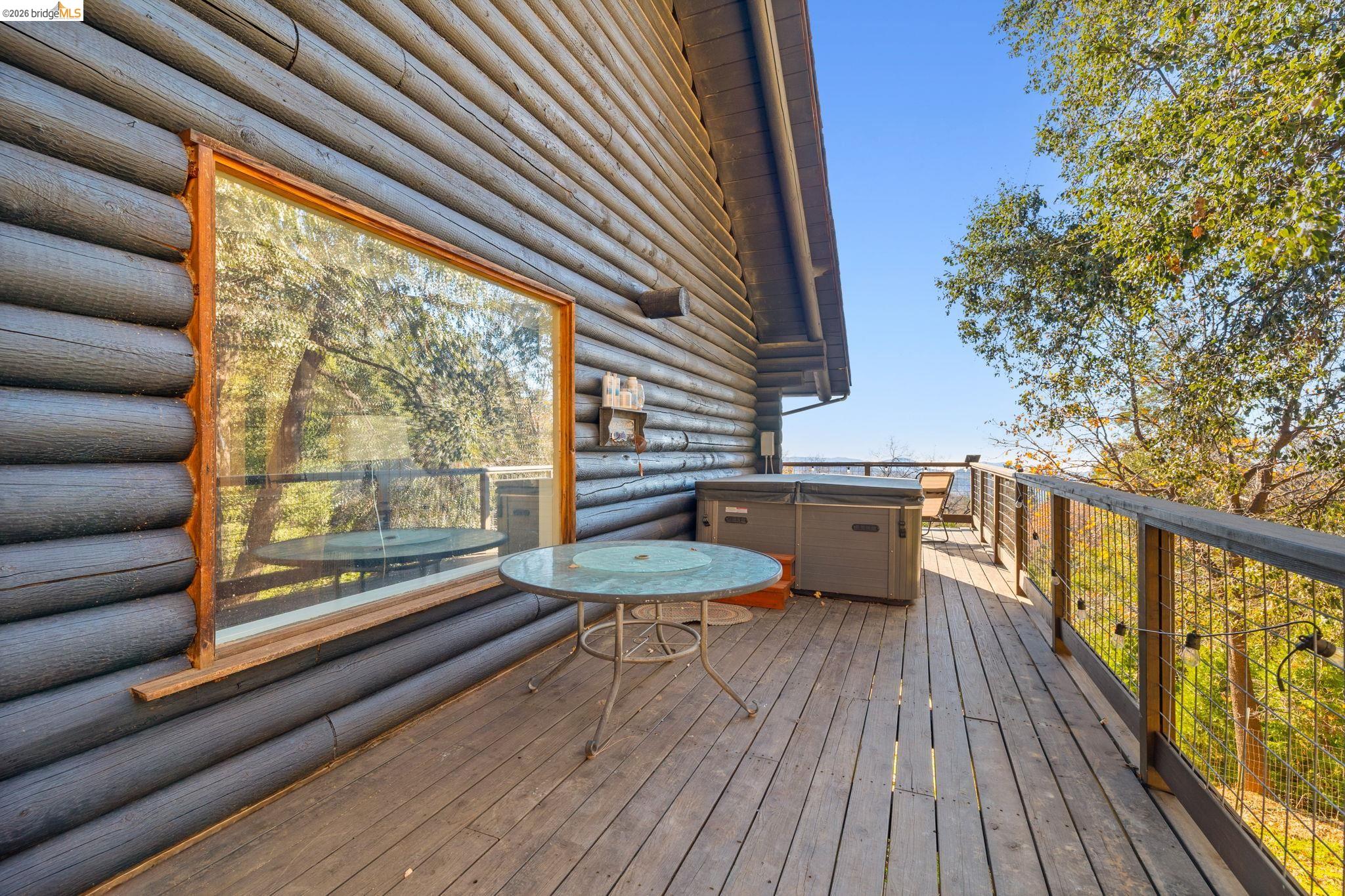 16144 Big Hill Road Sonora, CA 95370 - Photo 32 of 51 Log cabin exterior featuring a spacious wooden deck with a built-in hot tub
