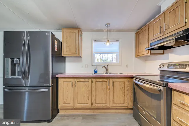 a kitchen with a refrigerator sink and cabinets