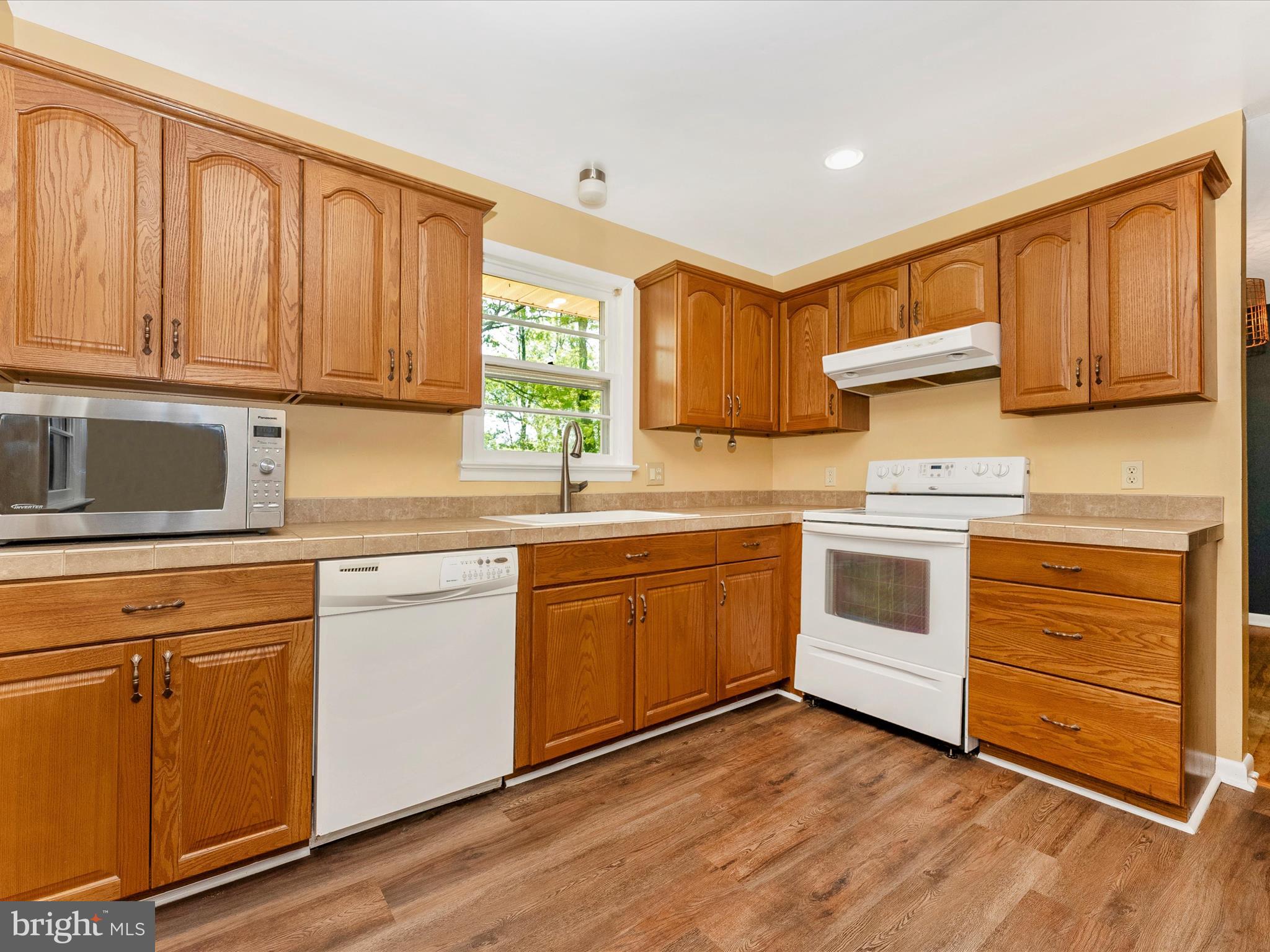 2833 Roderick Road Frederick, MD 21704 - Photo 3 of 41 a kitchen with granite countertop wooden cabinets and white appliances