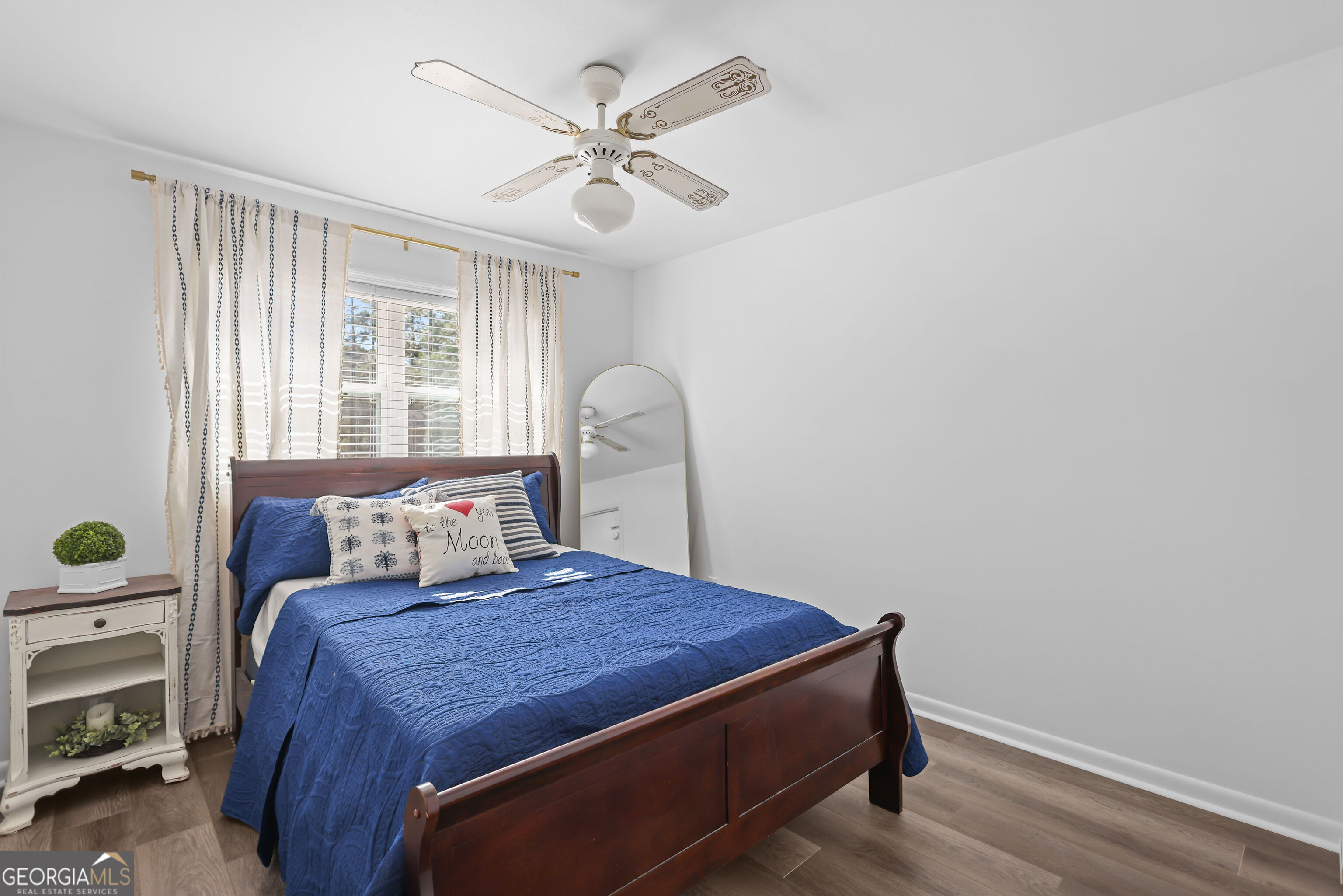 548 South 5th Street Jesup, GA 31545 - Photo 23 of 45 a bed sitting in a bedroom next to a window with a chandelier and a window
