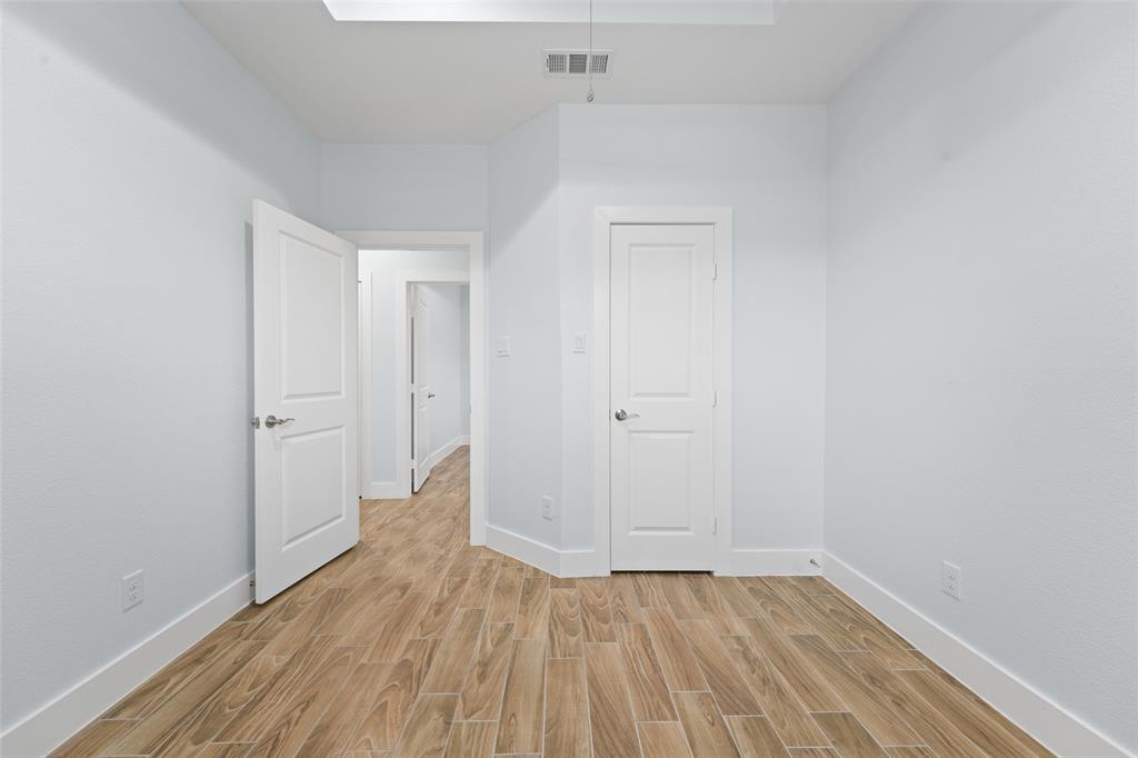 3807 Winding Road Arlington, TX 76016 - Photo 18 of 23 Room featuring wood-look tile flooring, light-toned walls, white trim, and multiple white panel doors with brushed nickel hardware