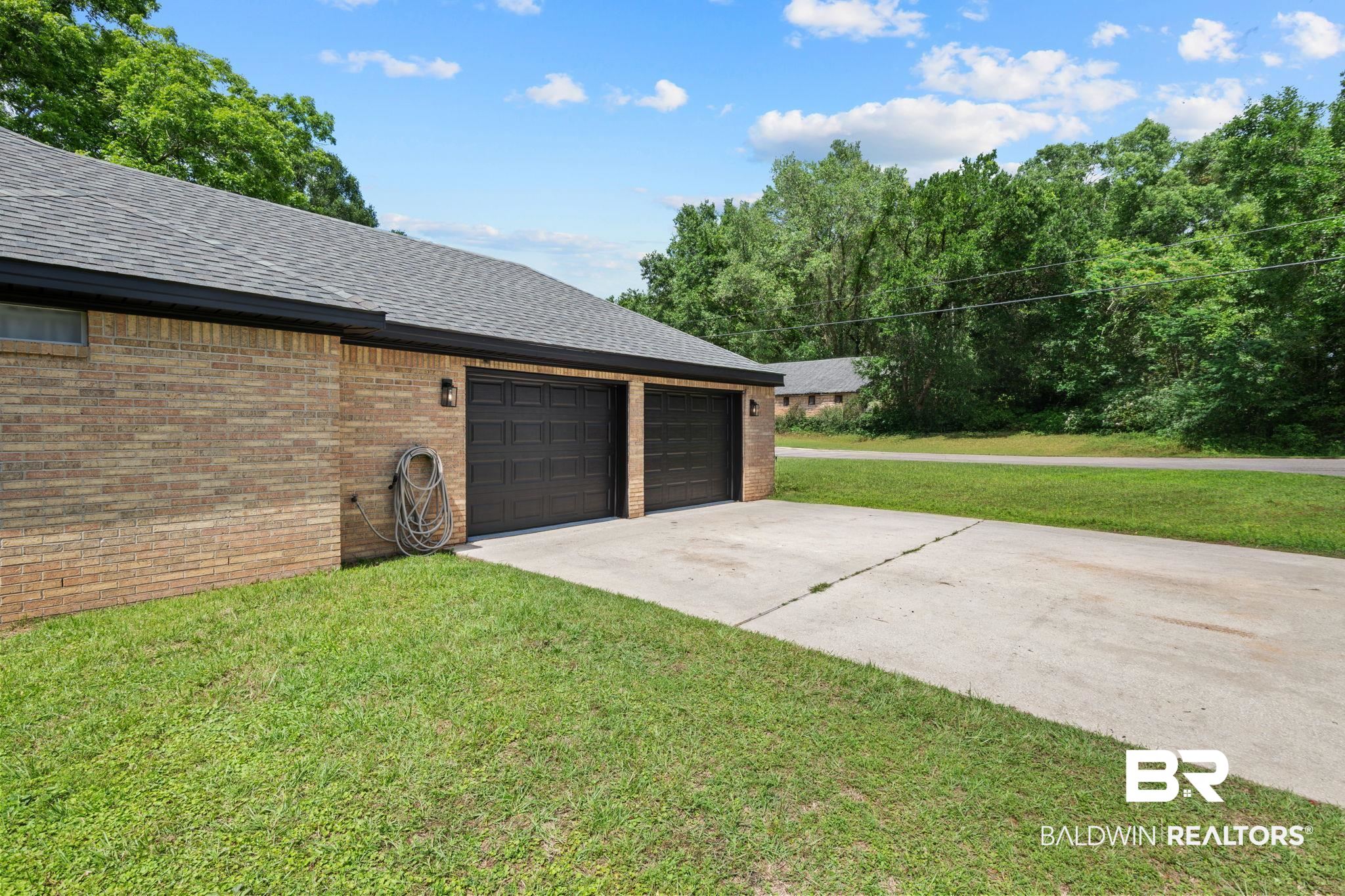 5936 Lundy Road Theodore, AL 36582 - Photo 25 of 32 Brick exterior with a dark-shingled roof and black gutters