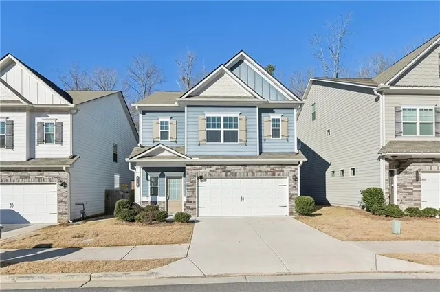 a front view of a house with yard and parking
