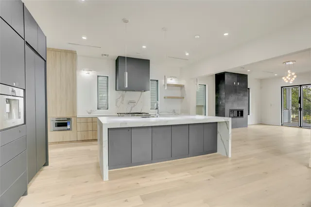 an empty room with kitchen and fireplace