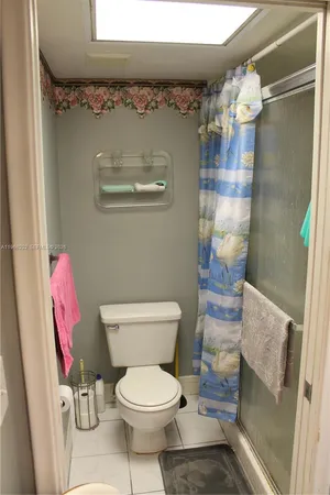 a white toilet sitting next to a bathroom sink and a mirror