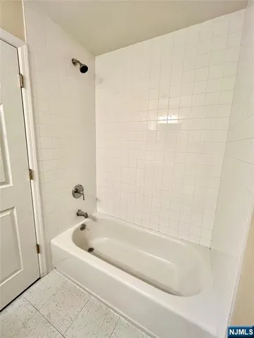 a white bath tub sitting next to a white sink and vanity