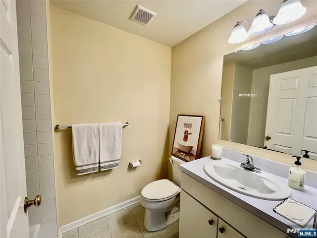 a bathroom with a sink vanity mirror and toilet
