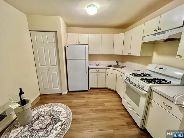 a kitchen with a stove a refrigerator and cabinets