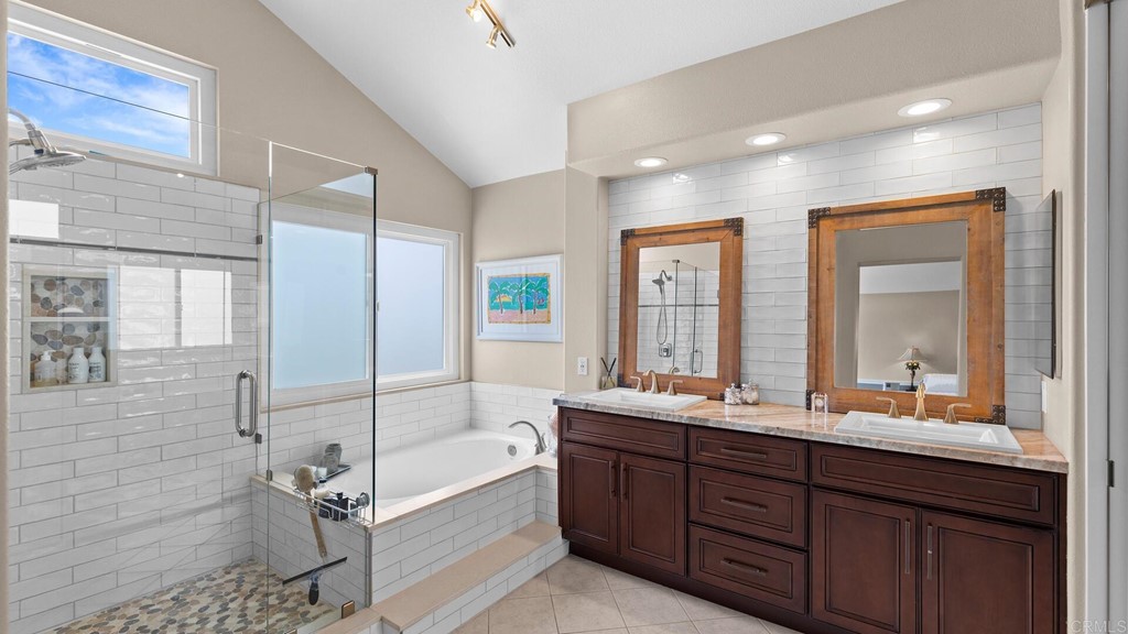 608 Crest Drive Encinitas, CA 92024 - Photo 11 of 25 a bathroom with a double vanity sink large mirror and a bathtub