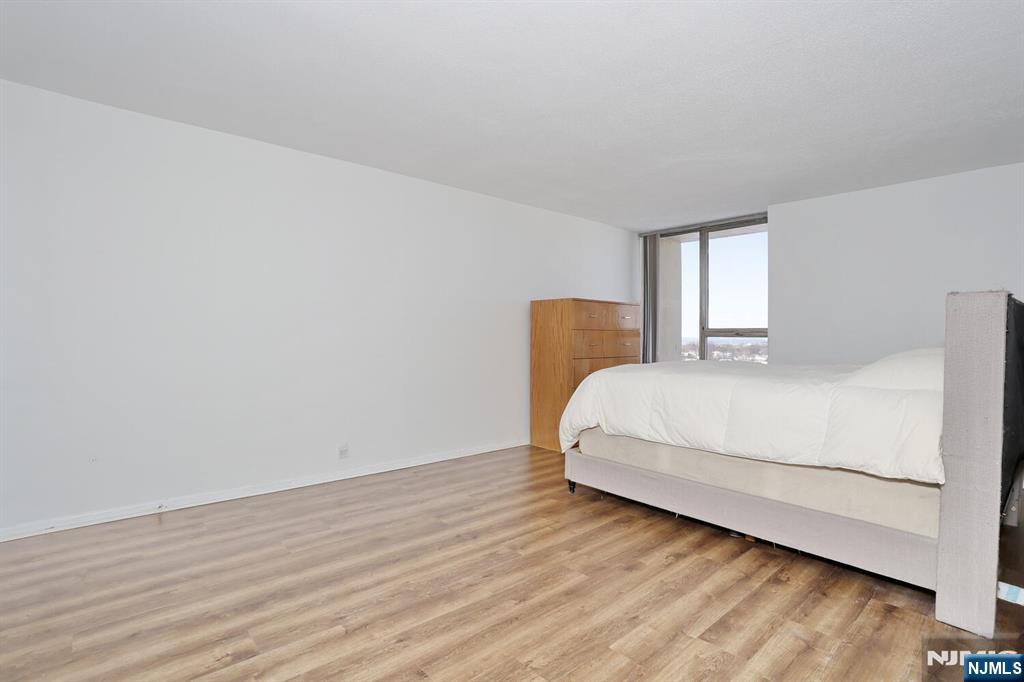 3 Horizon Road, Unit 1432 Fort Lee, NJ 07024 - Photo 32 of 49 a bedroom with a bed and wooden floor