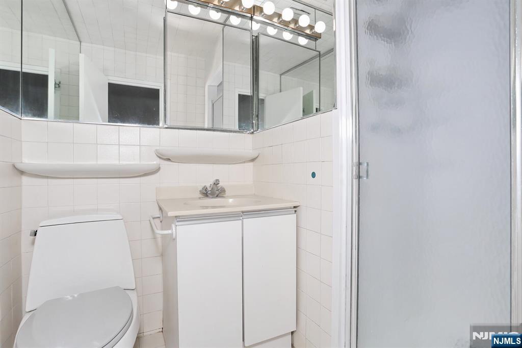 3 Horizon Road, Unit 1432 Fort Lee, NJ 07024 - Photo 35 of 49 a bathroom with a sink a toilet and mirror