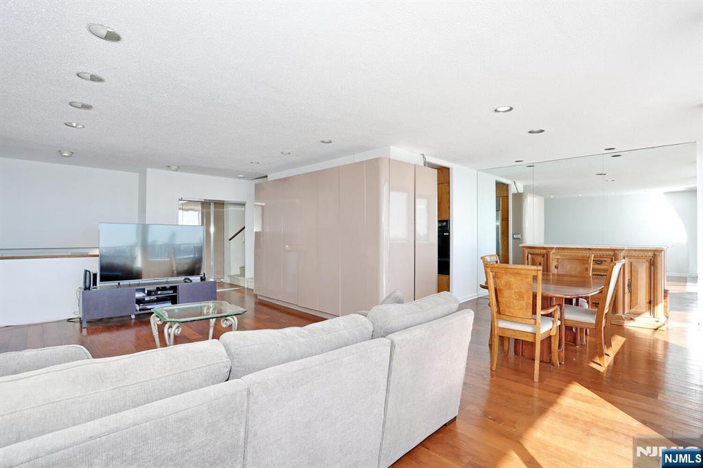 3 Horizon Road, Unit 1432 Fort Lee, NJ 07024 - Photo 10 of 49 a living room with furniture and a dining table with wooden floor