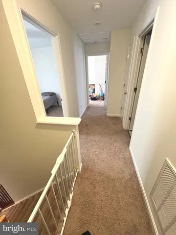 a view of a hallway to a house with wooden floor and stairs