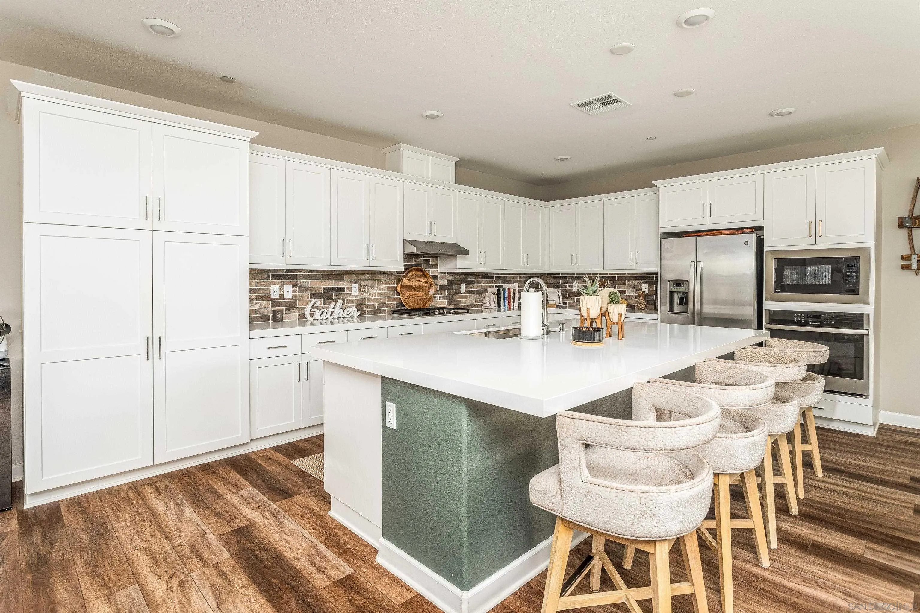 2066 Bruno Place Escondido, CA 92026 - Photo 5 of 33 a kitchen with stainless steel appliances granite countertop a stove a refrigerator a sink a dining table and chairs with wooden floor