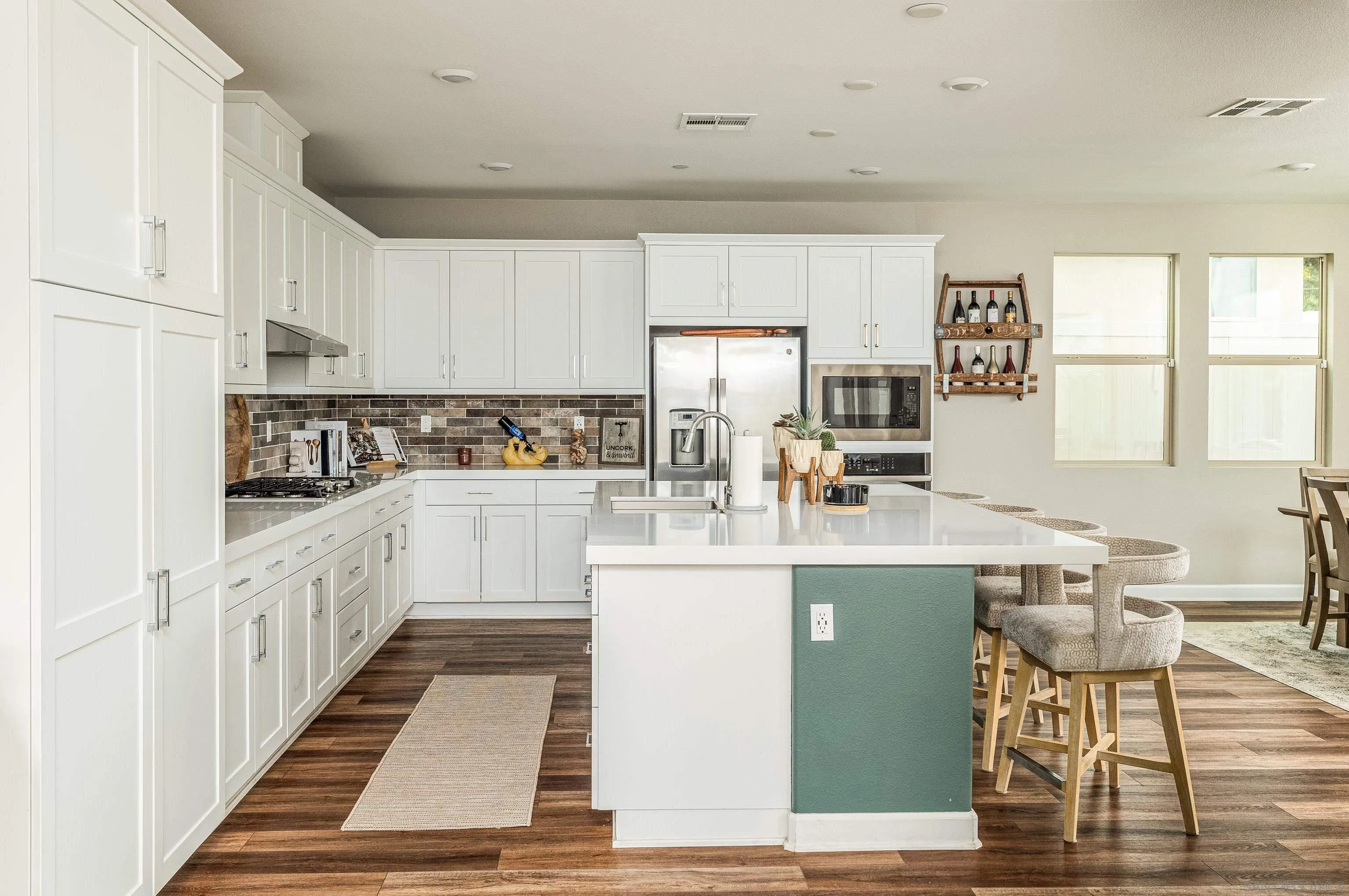 2066 Bruno Place Escondido, CA 92026 - Photo 7 of 33 a kitchen with stainless steel appliances granite countertop a stove top oven a sink dishwasher and white cabinets with wooden floor