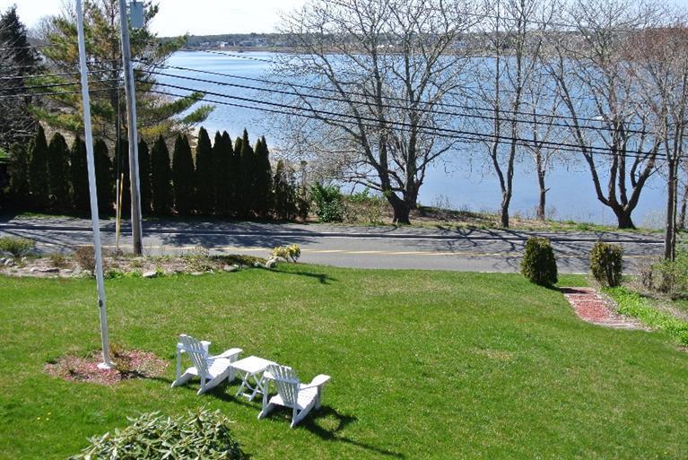 155 Stage Harbor Road Chatham, MA 02633 - Photo 2 of 11 a backyard of a house with lots of green space and fountain
