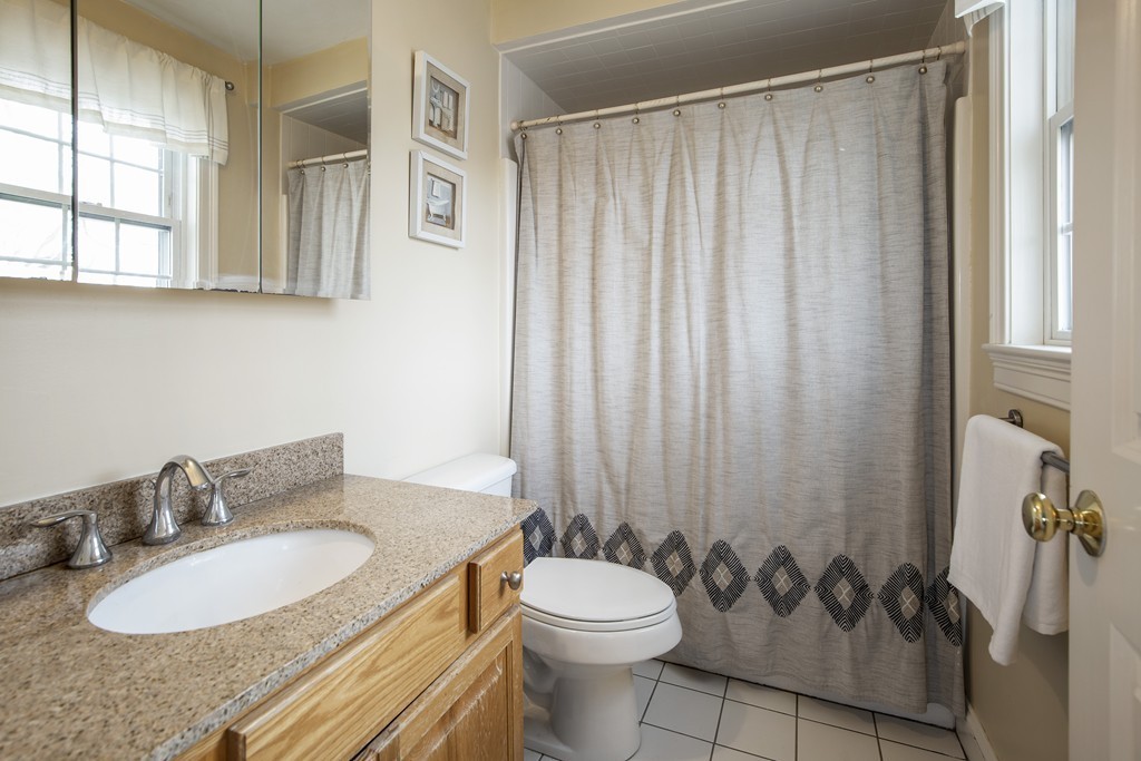 24 Wall Street, Unit E Canton, MA 02021 - Photo 11 of 19 a bathroom with a granite countertop sink and a mirror
