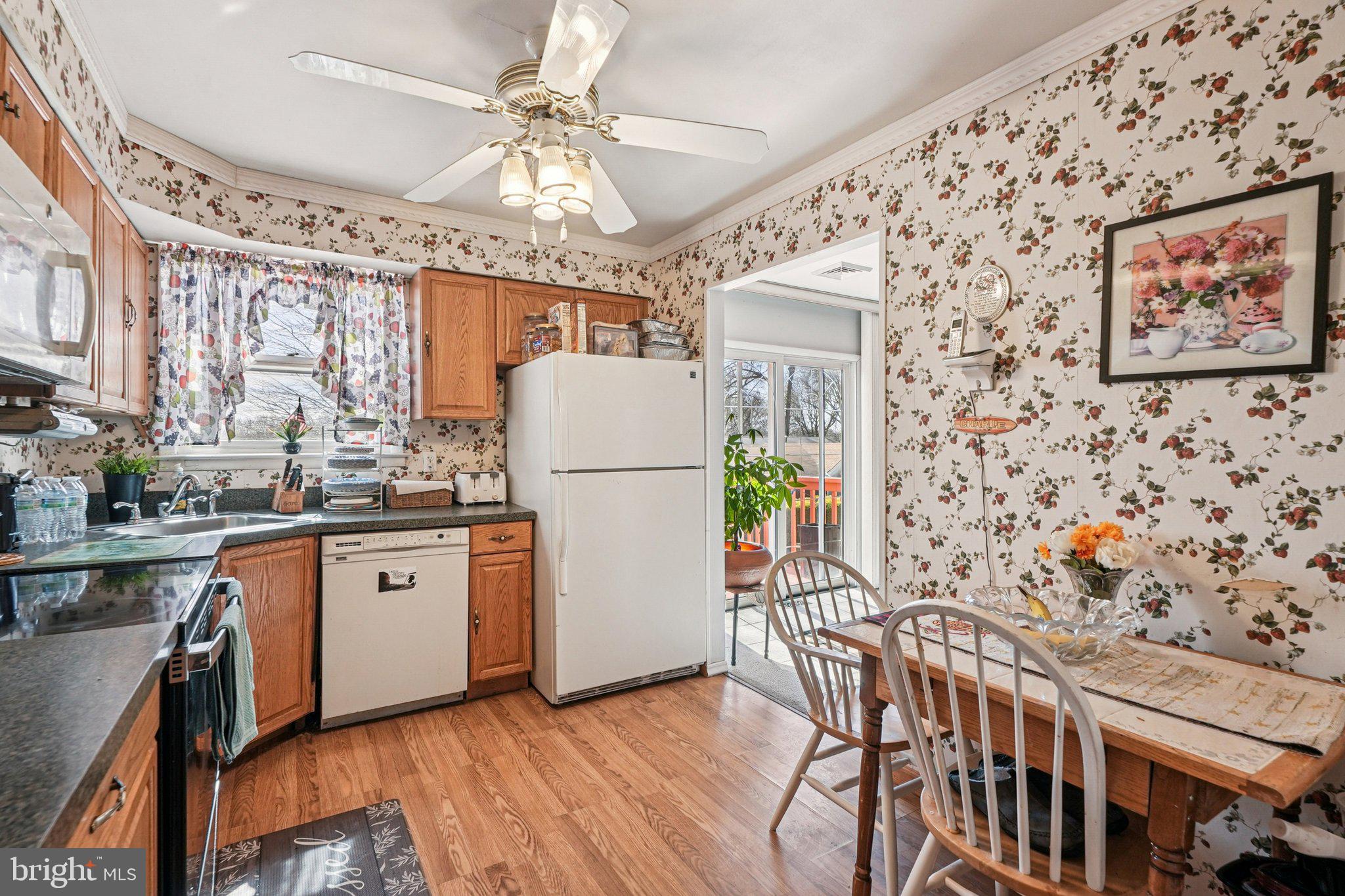 41 Harding Street Ewing, NJ 08618 - Photo 15 of 50 a open kitchen with stainless steel appliances granite countertop a refrigerator a stove a sink dishwasher a dining table and chairs with wooden floor