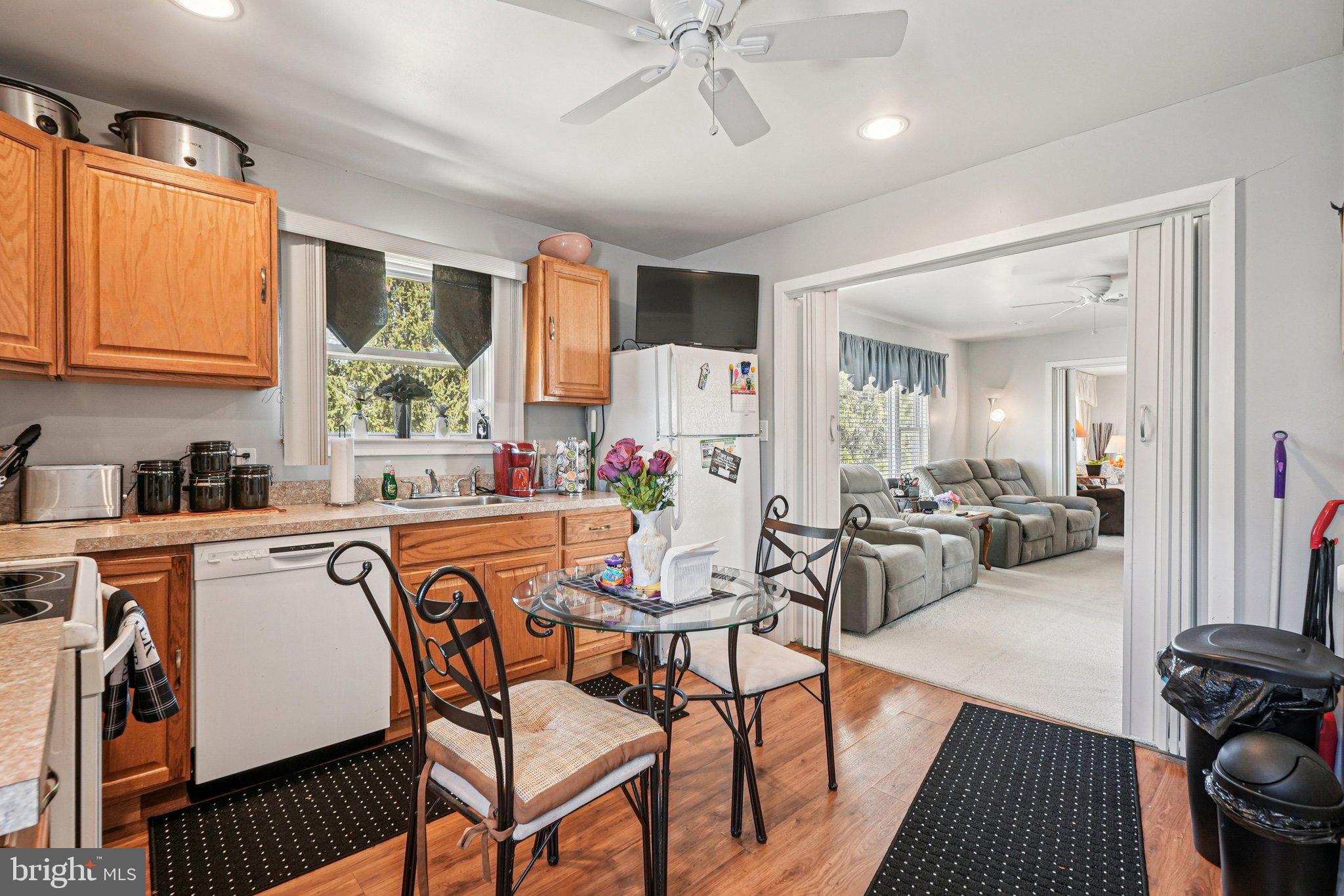 41 Harding Street Ewing, NJ 08618 - Photo 17 of 50 a kitchen with stainless steel appliances granite countertop a stove a sink dishwasher a dining table and chairs with wooden floor