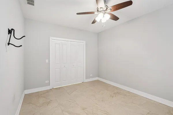 an empty room with a fan & a window