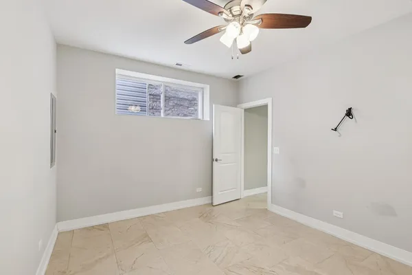 an empty room with a window and a fan