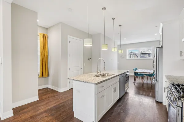 a open kitchen with stainless steel appliances granite countertop a stove and a wooden floor