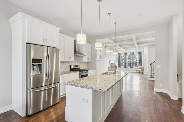 a kitchen with kitchen island a counter top space wooden floor and appliances