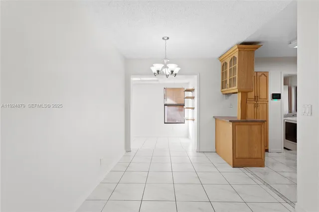 a view of a kitchen with refrigerator and cabinets