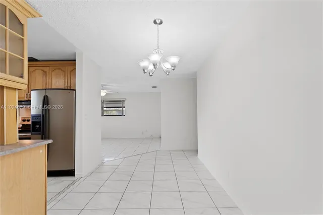 a kitchen with a refrigerator a sink and dishwasher with white cabinets