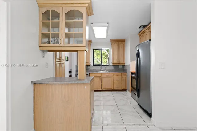 a view of a kitchen with fridge and wooden floor