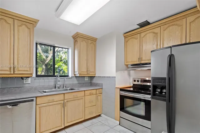 a kitchen with stainless steel appliances granite countertop a refrigerator sink and cabinets