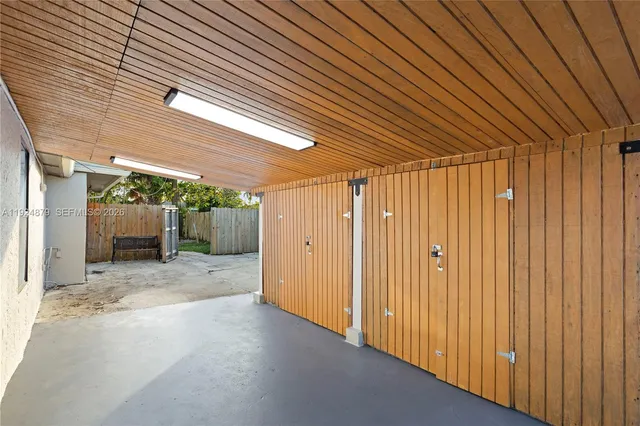 a view of backyard of house with wooden fence
