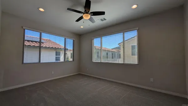 an empty room with a ceiling fan and a window